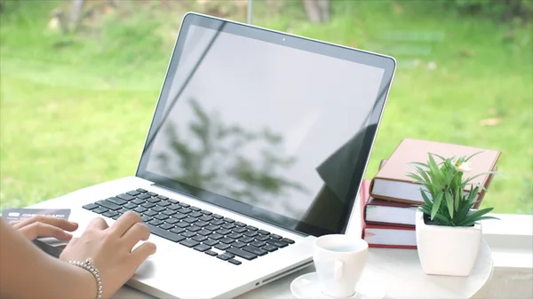 Von hinten tippt junge Frau auf Laptop — Stockfoto