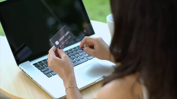 Achter van credit card van de transactie van de jonge vrouw op laptop — Stockfoto