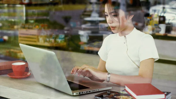 Menina adolescente asiática bonita está conversando em um laptop — Fotografia de Stock