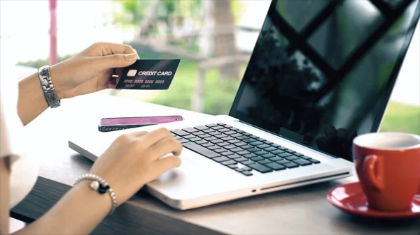 Achter van jonge vrouw te typen op de laptop en creditcard voor shopp — Stockfoto