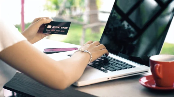 Achter van jonge vrouw te typen op de laptop en creditcard voor shopp — Stockfoto