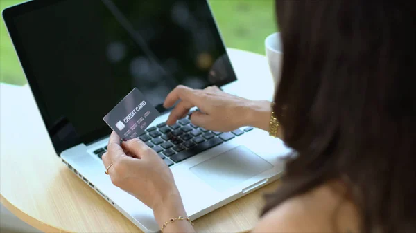 Achter van credit card van de transactie van de jonge vrouw op laptop — Stockfoto