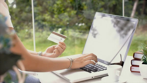 Jonge vrouw te typen op laptop toetsenbord en gebruik van creditcard transa — Stockfoto