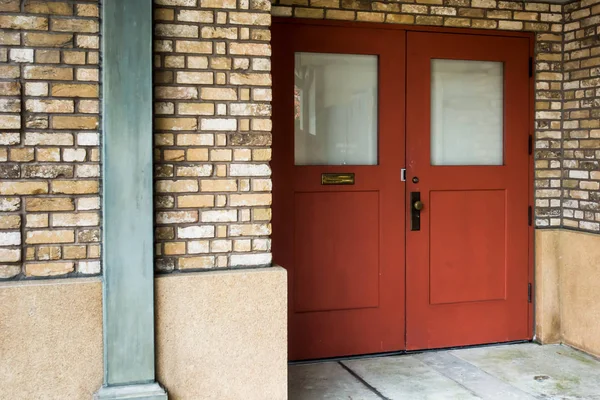 Червоні дерев'яні двері зі склом і старою цеглою — стокове фото