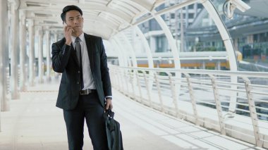 Asya genç işadamı o yürüyüş sırasında Smartphone ile konuşmak