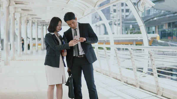 Young man and pretty woman are checking map on smartphone — Stock Photo, Image