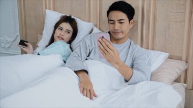 Genç evli çift yatağa sohbet smartphone kullanılan