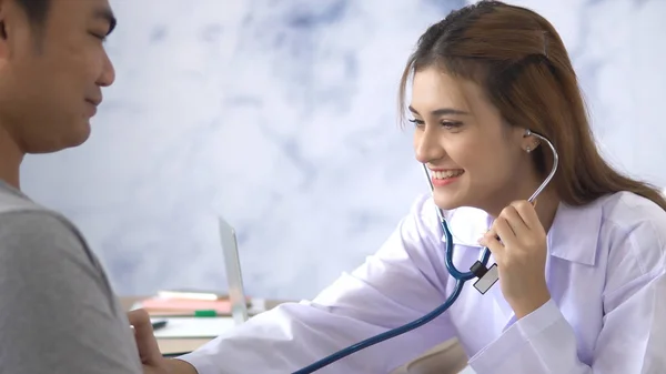 Femmina medico parlando con giovane paziente uomo in ospedale — Foto Stock