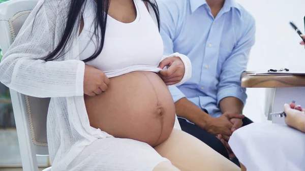 Paño abierto joven embarazada para mostrar su vientre al médico —  Fotos de Stock