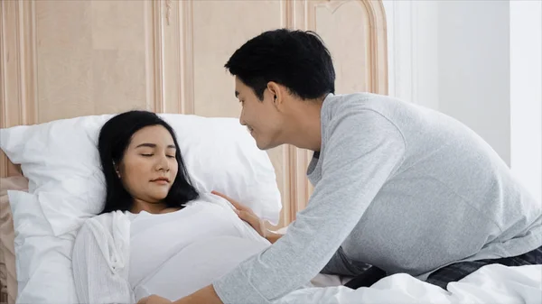 Молодой муж проверяет свою жену беременной, когда она больна — стоковое фото