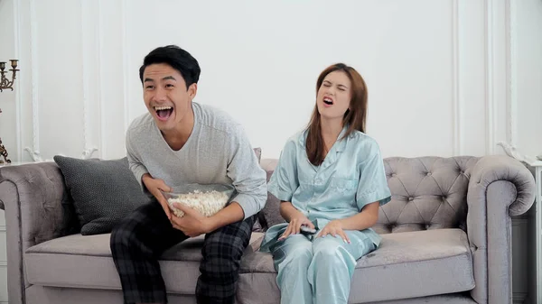 Jovem casal gosta de assistir televisão e usar controle remoto — Fotografia de Stock