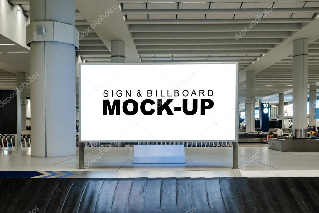 Mock up blank large horizontal billboard with clipping path at baggage claim point in airport terminal, empty space for advertising or public information, advertisement concept