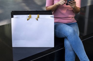 Beyaz kağıt alışveriş torbası üzerinde boş ekranı olan genç, güzel bir kadın kırpma yolu ile modellenir, alışveriş torbası üzerinde boş bir alan olur logo ya da reklam için grafik yerleştirilir, kopyalama alanı oluşturulur.