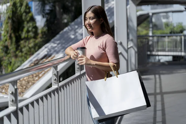 Young female holding two bag, mockup blank screen paper shopping bag with clipping path, Empty space on shopping bag for design insert logo or graphic.