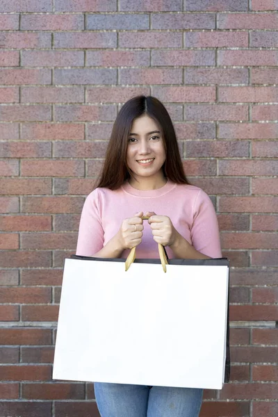 Young female holding two bag, mockup blank screen paper shopping bag with clipping path, Empty space on shopping bag for design insert logo or graphic.