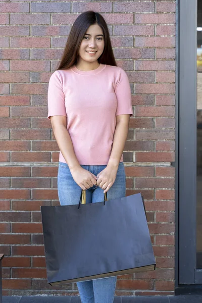 Young female holding two bag, mockup blank screen paper shopping bag with clipping path, Empty space on shopping bag for design insert logo or graphic.