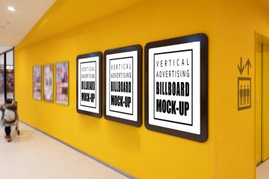 Alış veriş merkezinin duvarında üç kahverengi çerçeveli kesik yolu olan boş posterler, yürüyen insanları bulanıklaştıran, kapalı alandaki reklam afişleri için kurulmuş boş uzay çerçeveleri.