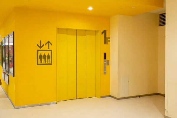 The Elevator in the modern building, Closed gates entrance for transportation at first floor. Blurred people walking, empty space for advertising large indoor poster.