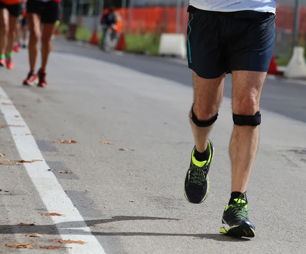Atleta corredor durante a corrida com o curativo — Fotografia de Stock