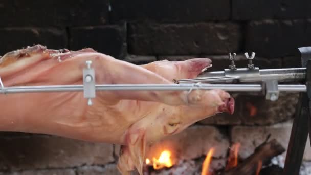 Spit with a big roast pork while cooking — Stock Video