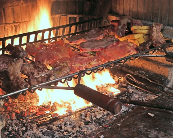 Fuego caliente para cocinar costillas de cerdo y sabrosa salchicha picante a la parrilla —  Fotos de Stock