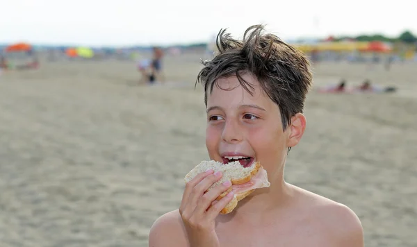 Killen medan man äter en smörgås på stranden på sommaren — Stockfoto