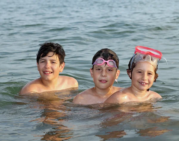 Три дружелюбных брата купаются в океане во время летних каникул — стоковое фото