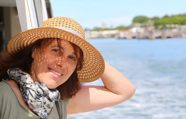 Smiling beautiful woman with straw hat while cruising — Stock Photo, Image