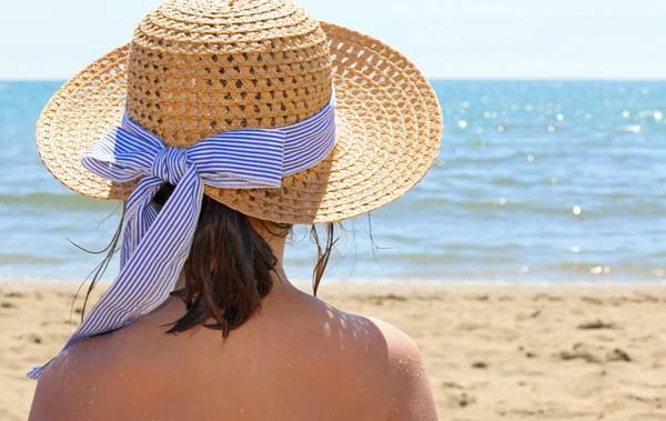 Junge Person mit Strohhut am schönen Meer — Stockfoto