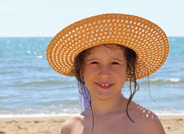 Маленькая девочка в соломенной шляпе у моря летом — стоковое фото