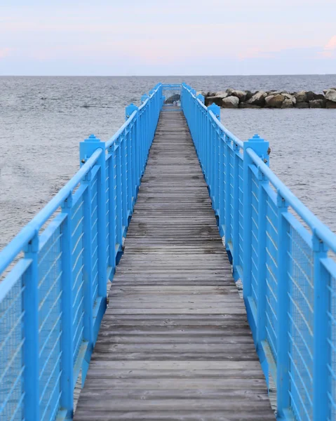 Lange brug naar dock schepen op zee — Stockfoto