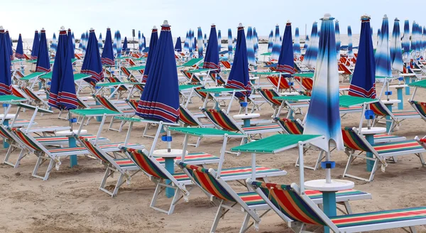 Множество пляжных стульев и зонтиков — стоковое фото
