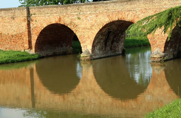 Oude gewelfde brug gemaakt van rode bakstenen — Stockfoto