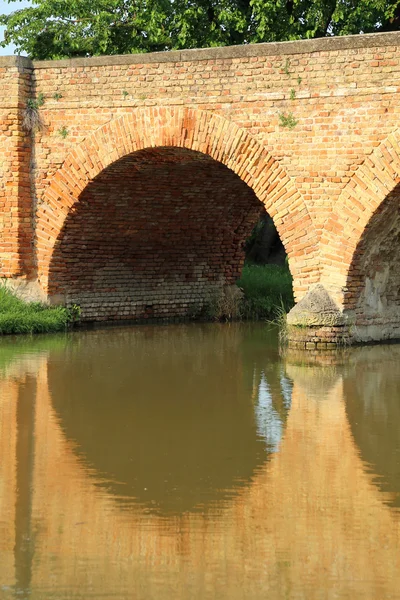 Bogenbrücke aus Ziegeln mit dem Fluss — Stockfoto