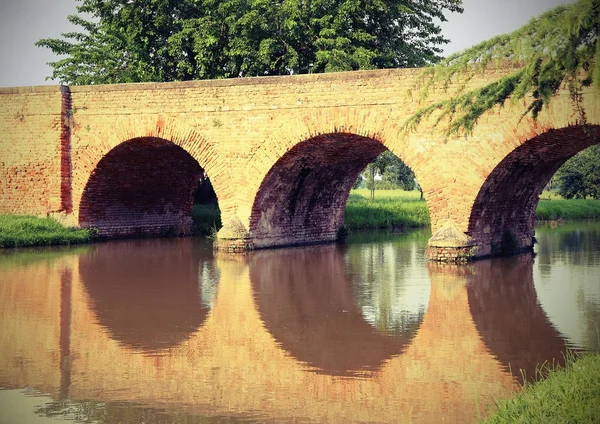 Oude gewelfde brug gemaakt van rode bakstenen — Stockfoto