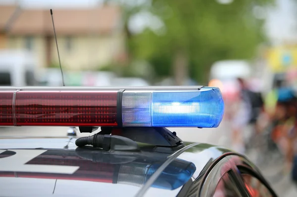 Blue flashing lights of the police car at a sports event — Stock fotografie