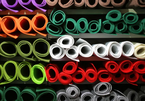 Scaffale con rotoli di feltro colorati in vendita nel grande negozio di tessuti — Foto Stock