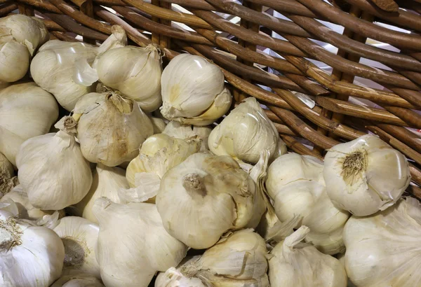 Hintergrund der Knoblauchzehen zum Verkauf im Weidenkorb — Stockfoto