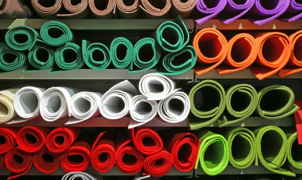 Étagère avec de nombreux rouleaux de feutre coloré à vendre dans le stalle du marché — Photo