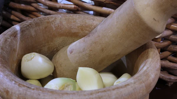 Artisan wooden pestle with garlic cloves — Stock Photo, Image