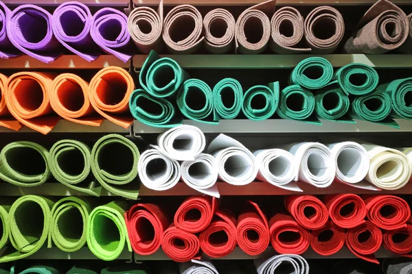 Shelf with felt rolls for sale in the market stall in large fabr — Stock Photo, Image