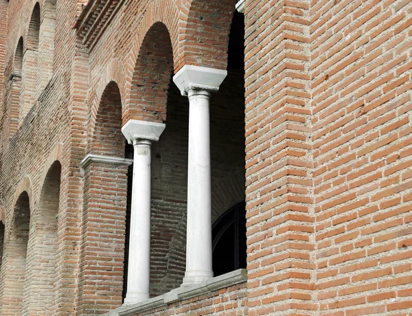 Arched windows and columns on the facade of an old medieval chur — Stock Photo, Image