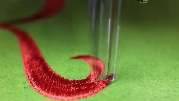 Sewing machine while embroidering with red thread on green background — Stock Video