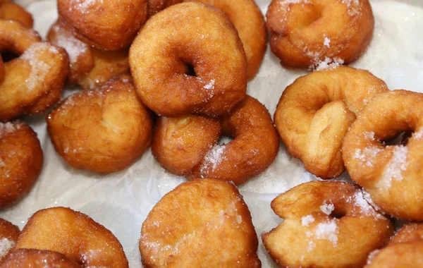 Tasty donuts and pancakes with powdered sugar — Stock Photo, Image