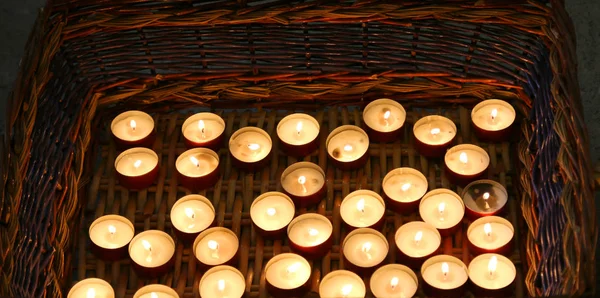 Velas acesas na cesta de vime durante a celebração religiosa — Fotografia de Stock