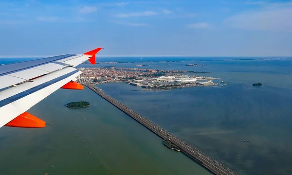 Flygeln av ett passagerarflygplan över bron av frihet i Venedig i — Stockfoto