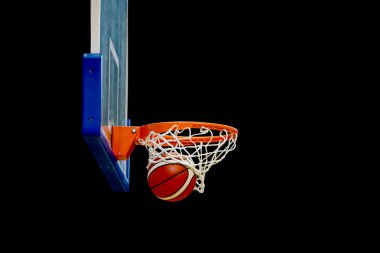 Basketbol siyah bir arka plan ile sepet girer