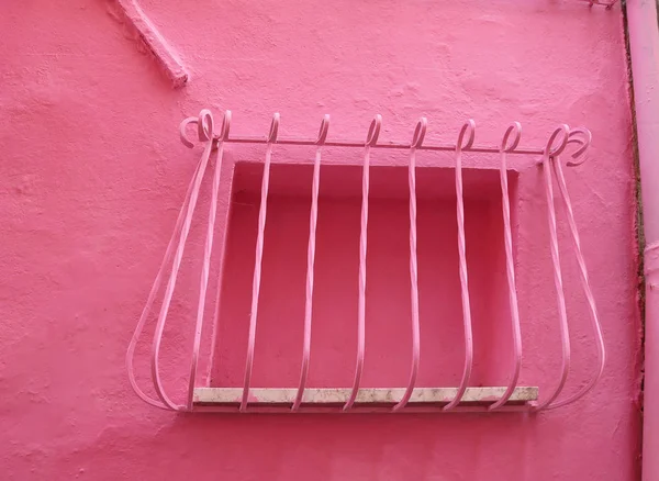 Rosa muromgärdade fönster med baren i ett litet rosa hus — Stockfoto