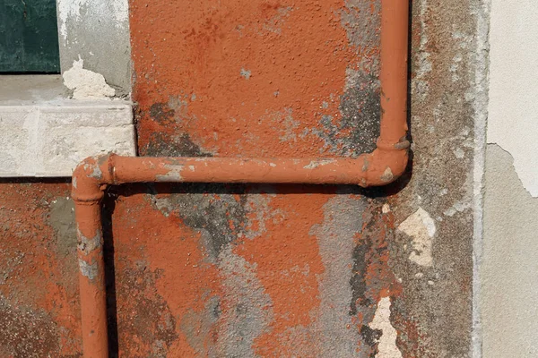 Gas pipe on the peeling wall of an old house — Stock Photo, Image