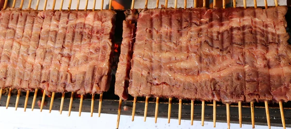 Many meat skewers of lamb cooked on the grill in the street — Stock Photo, Image